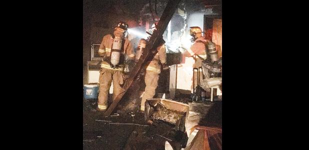 CDN | Staff Photo Clinton firemen work to extinguish a blaze Tuesday night at 223 Rawlings. From the left are Volunteer D.J. Woodall, Fire Chief Forrest Valentine, and Firefighter Caleb Moore.