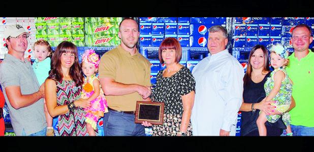 CDN | Robert S. Bryan Debra and Mark Nicholson, center right, owners of the Pepsi-Cola distributorship in Clinton, receive their plaque as Business Persons of the Year from Rotarian and outgoing Chamber Chair Patch McComas. Other members of the Nicholson family, from the left, are Levi holding Hutton, Sara holding Har-per, and at right, Baily Kauk holding Audrey Kauk, and Clay Kauk.
