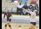 Junior Katy Eddy hits the ball back over the net, while sophomore Savannah Sikes looks on. It was a rough four set loss for the Reds. They dropped the opening set 26-24 and never recovered.