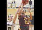 Clinton sophomore Aleisha Hester (No. 23) goes up with a runner against Woodward.
