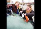 As many people were seen doing this week, Stacia Anderson, left, and Jillian England scrape an icy windshield before getting on the road. Article Image Alt Text