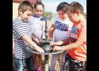 Kindergartners, from left, Izaias Wraspir, Valeria Guzman, Alexis Arrendondo and Elijah Cardwell clean debris out of the Reading Garden’s birdbath. CDN | Robert S. Bryan Article Image Alt Text