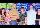 Debra and Mark Nicholson, center right, owners of the Pepsi-Cola distributorship in Clinton, receive their plaque as Business Persons of the Year from Rotarian and outgoing Chamber Chair Patch McComas. Other members of the Nicholson family, from the left, are Levi holding Hutton, Sara holding Har-per, and at right, Baily Kauk holding Audrey Kauk, and Clay Kauk.
